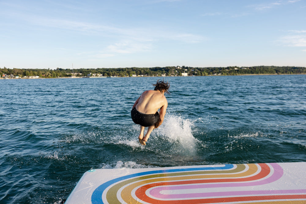 Person jumping into water from a colorful dock